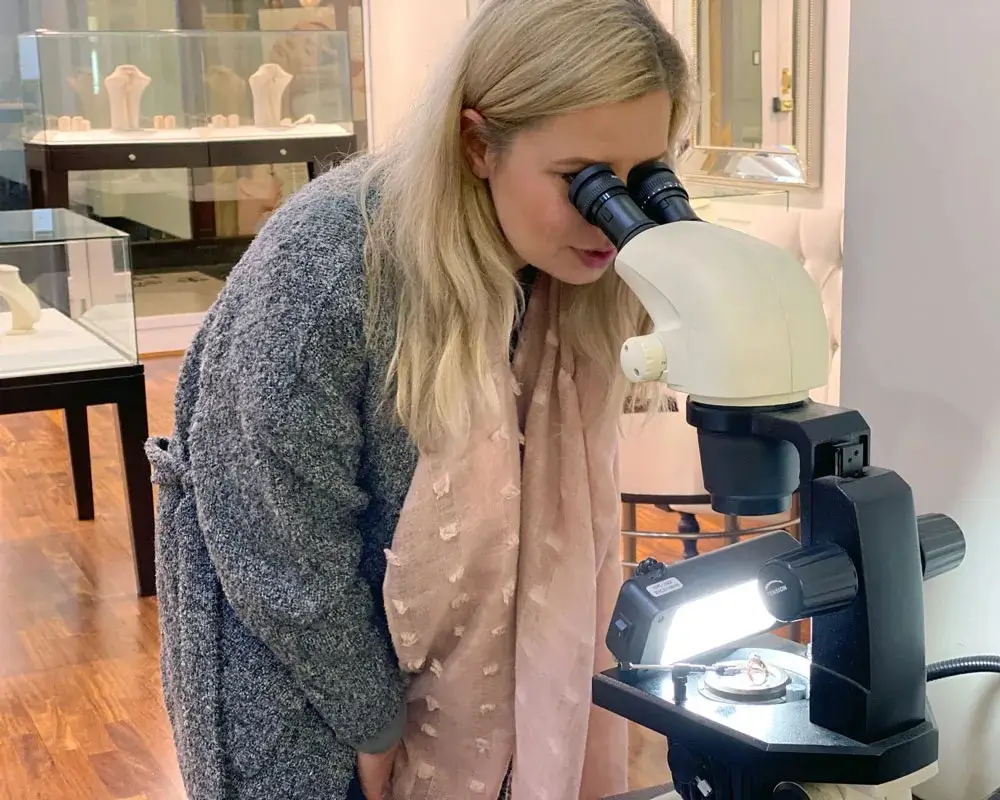 Client checking her ring under the microscope in the Daniella Jewellers showroom